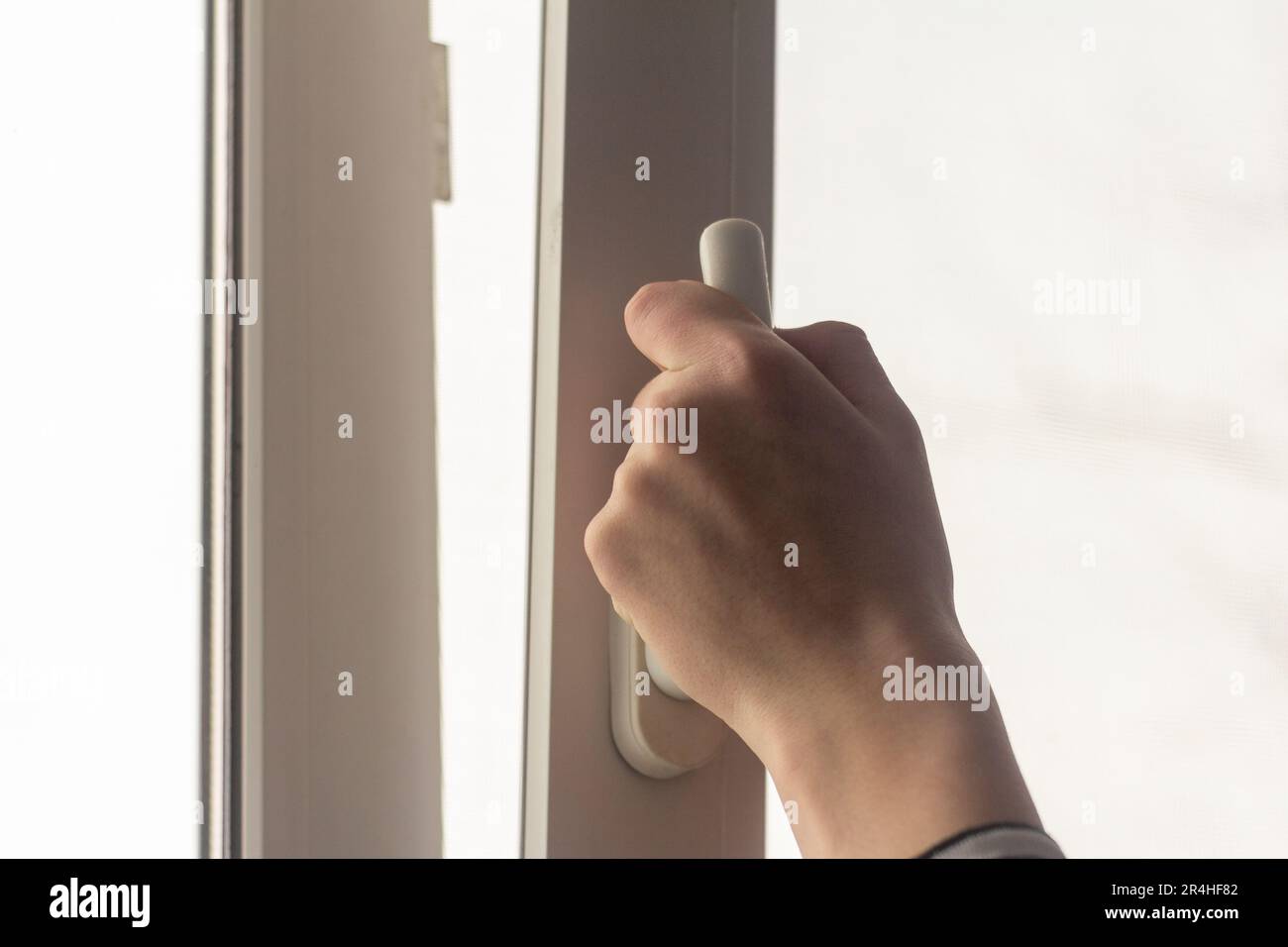 The teenager's hand opens the window to air out the room Stock Photo