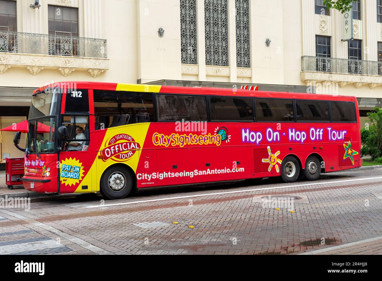 San Antonio, Texas, USA – May 9, 2023: A red City Sightseeing tour bus parked on Alamo Plaza in San Antonio, Texas. Stock Photo