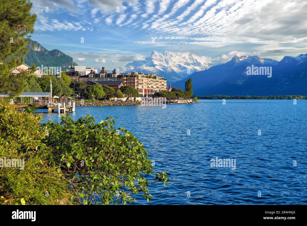 Beautiful summer evening panorama of Lake Geneva with picturesque shores against Alpine mountains in the rays of the setting sun in Montreux, Switzerl Stock Photo