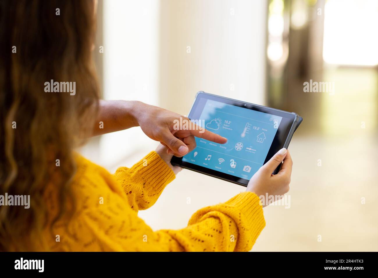 Biracial young woman controlling smart home with digital tablet and man ...