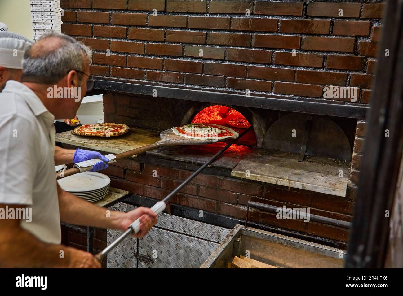 Naples, Italy - October 24, 2019: MICHELIN GUIDE ITALIA. L'Antica Pizzeria da Michele. Naples pizzeria. Naples, Italy. Man making Neopolitan pizza in Stock Photo