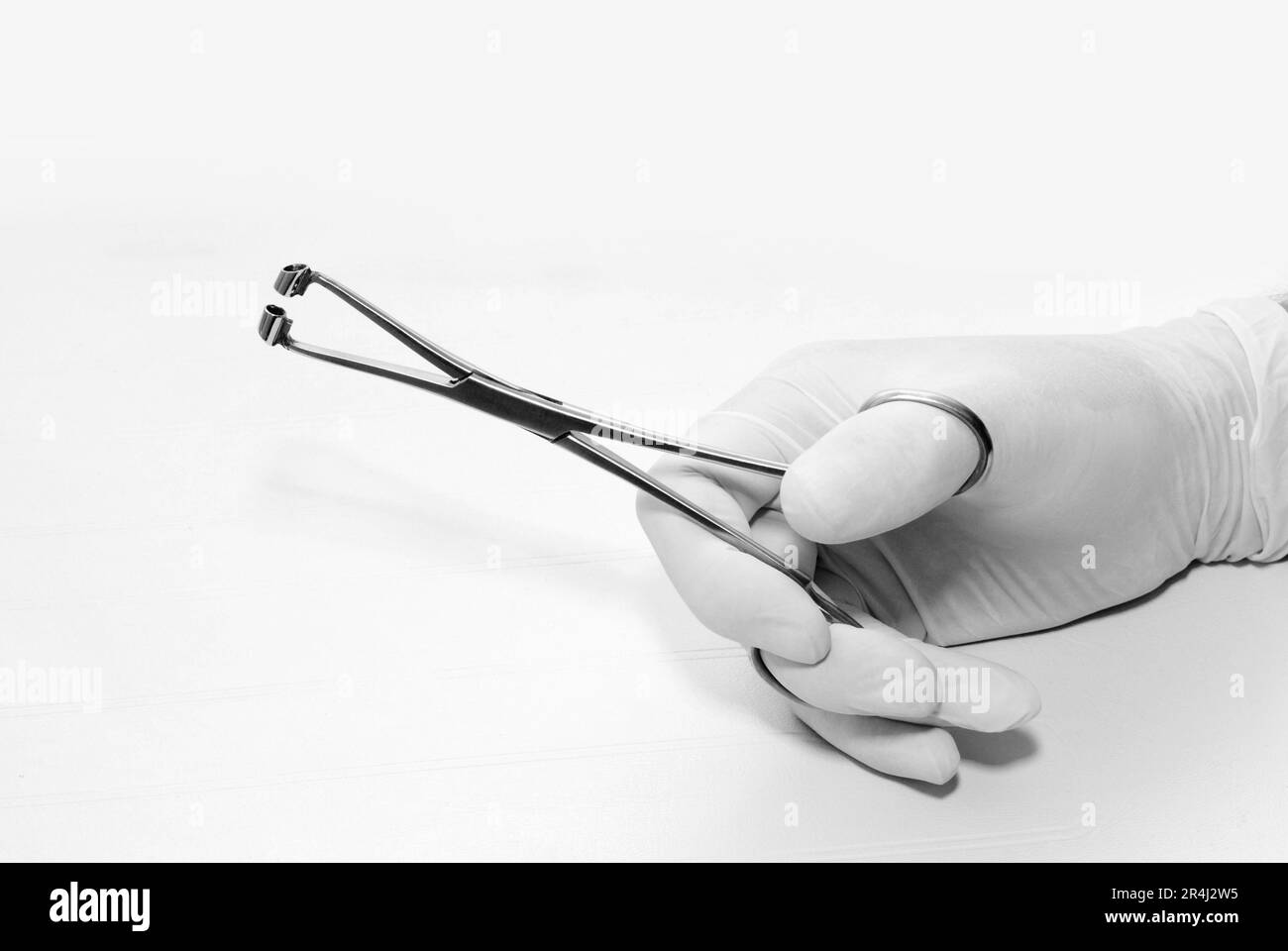 Hand, in the sterile glove, holding razzhy for clamp for piercing with