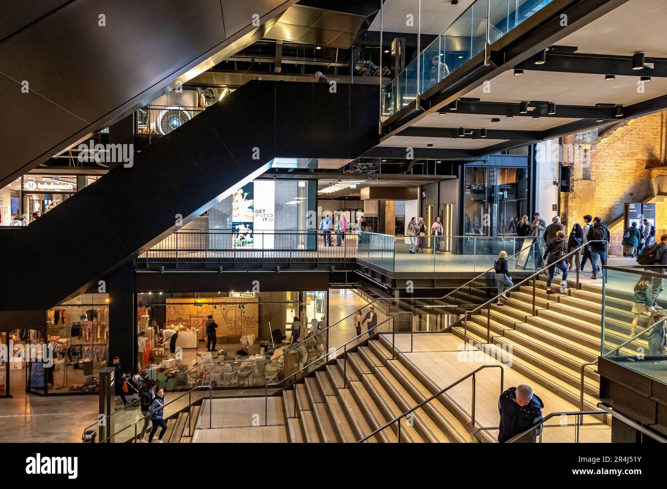 People on the stairs & escalators at the South entrance atrium at Battersea Power Station, now a major shopping and leisure destination, London, SW11 Stock Photo