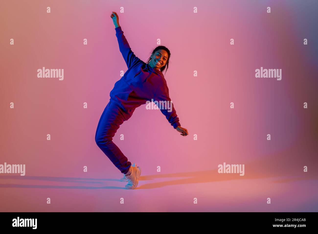 Sport dancing. Athletic and graceful black lady in sportwear dancing on ...