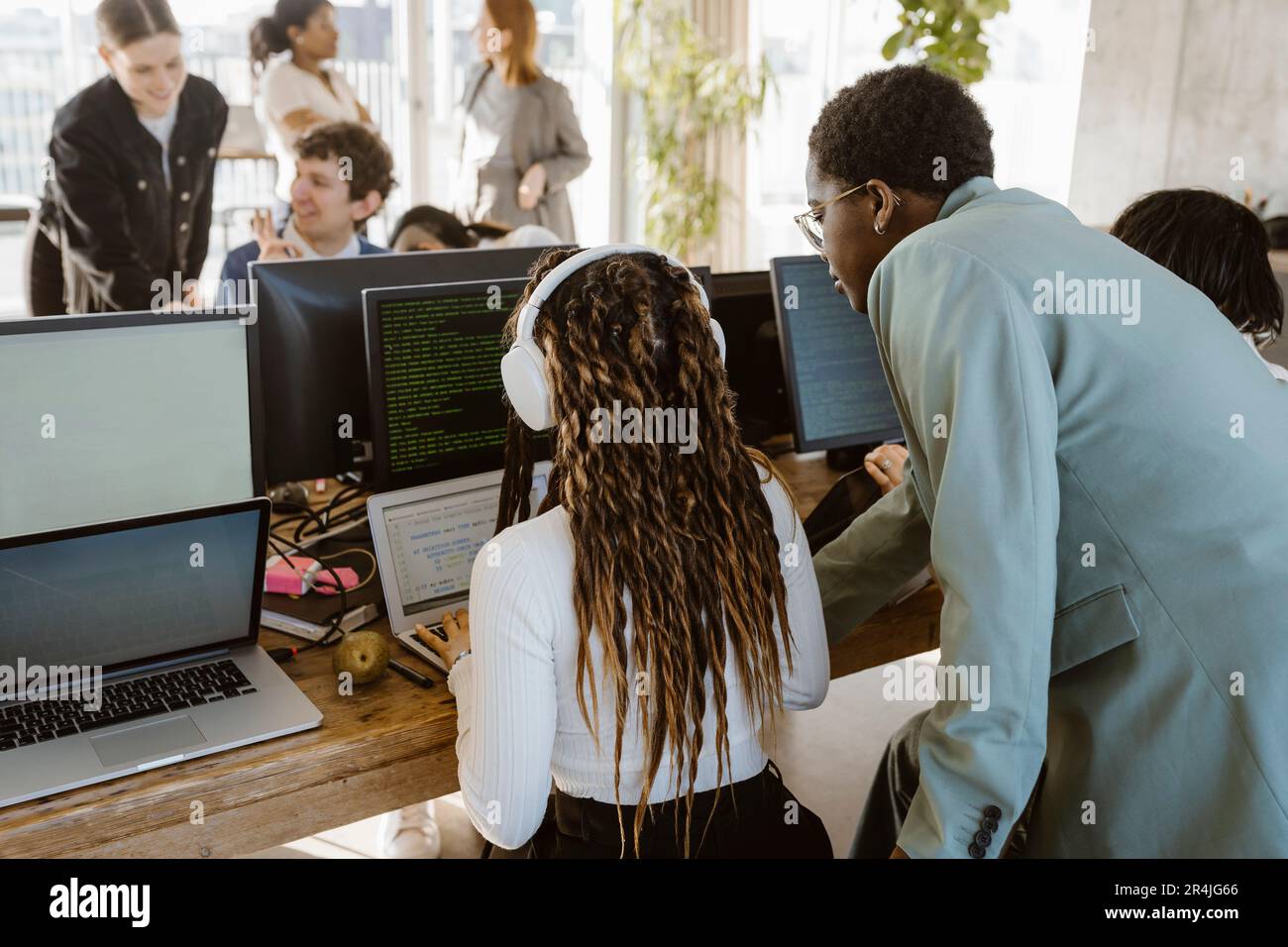 Multiracial programmers discussing over laptop at desk in office Stock Photo