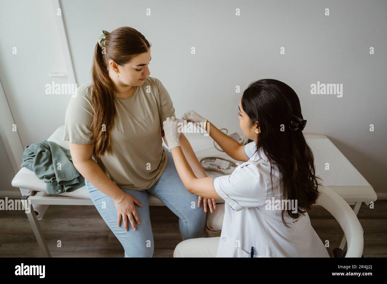 Doctor preparing female patient for medical exam at clinic Stock Photo