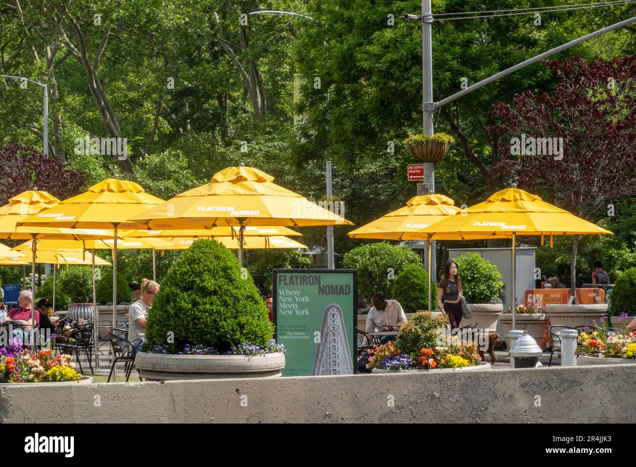 The public seating area at fifth Avenue and 23rd St. features bright yellow umbrellas for shade, 2023, New York City, NoMad, United States Stock Photo