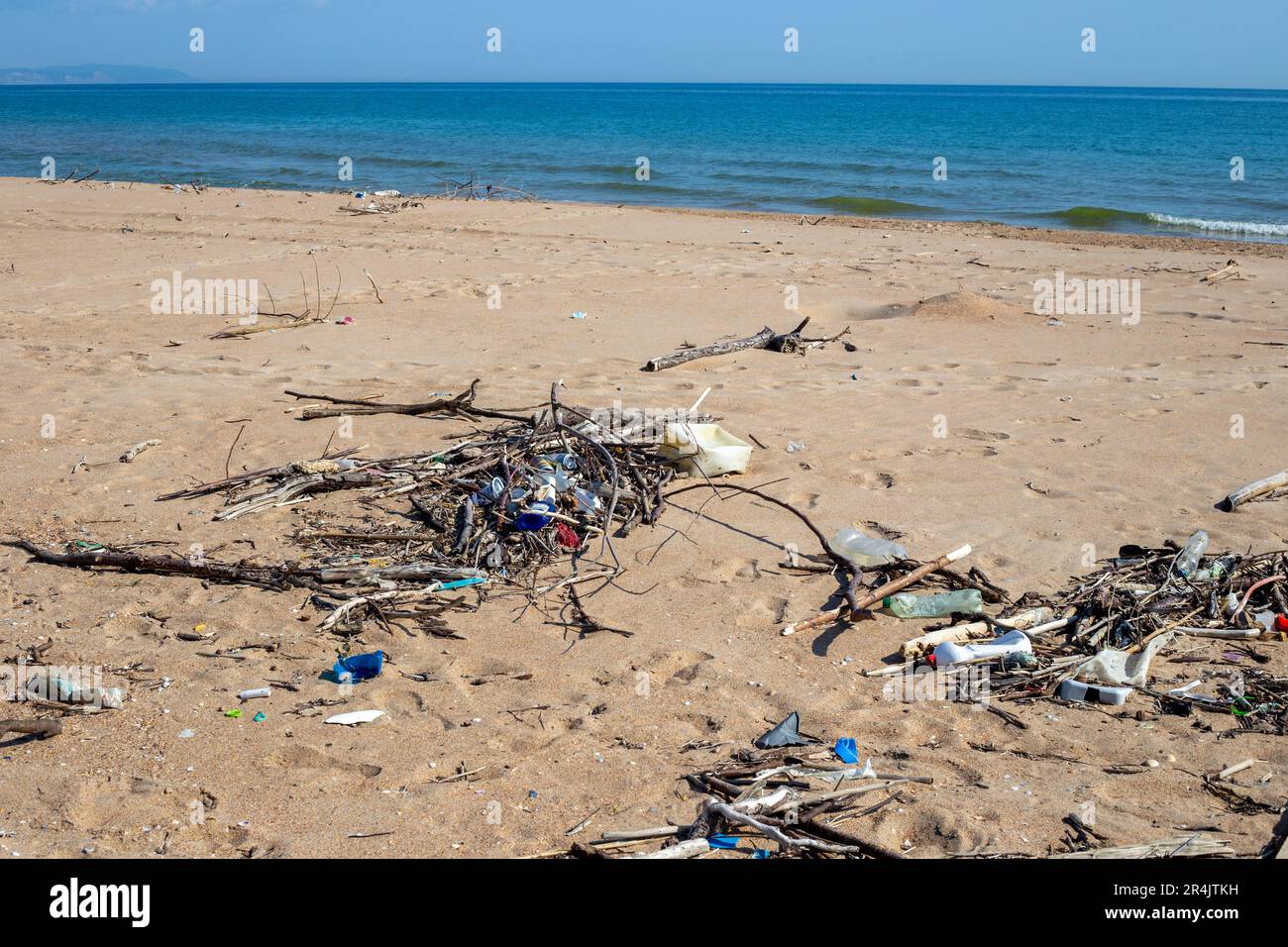 Sandy beach with a lot of garbage on the shore. Ecological catastrophy. Stock Photo
