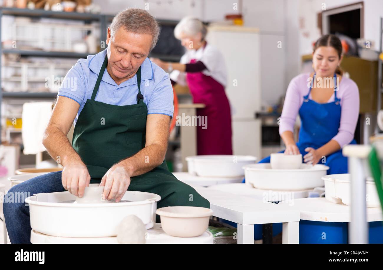 Mature male artist making pottery in studio Stock Photo - Alamy