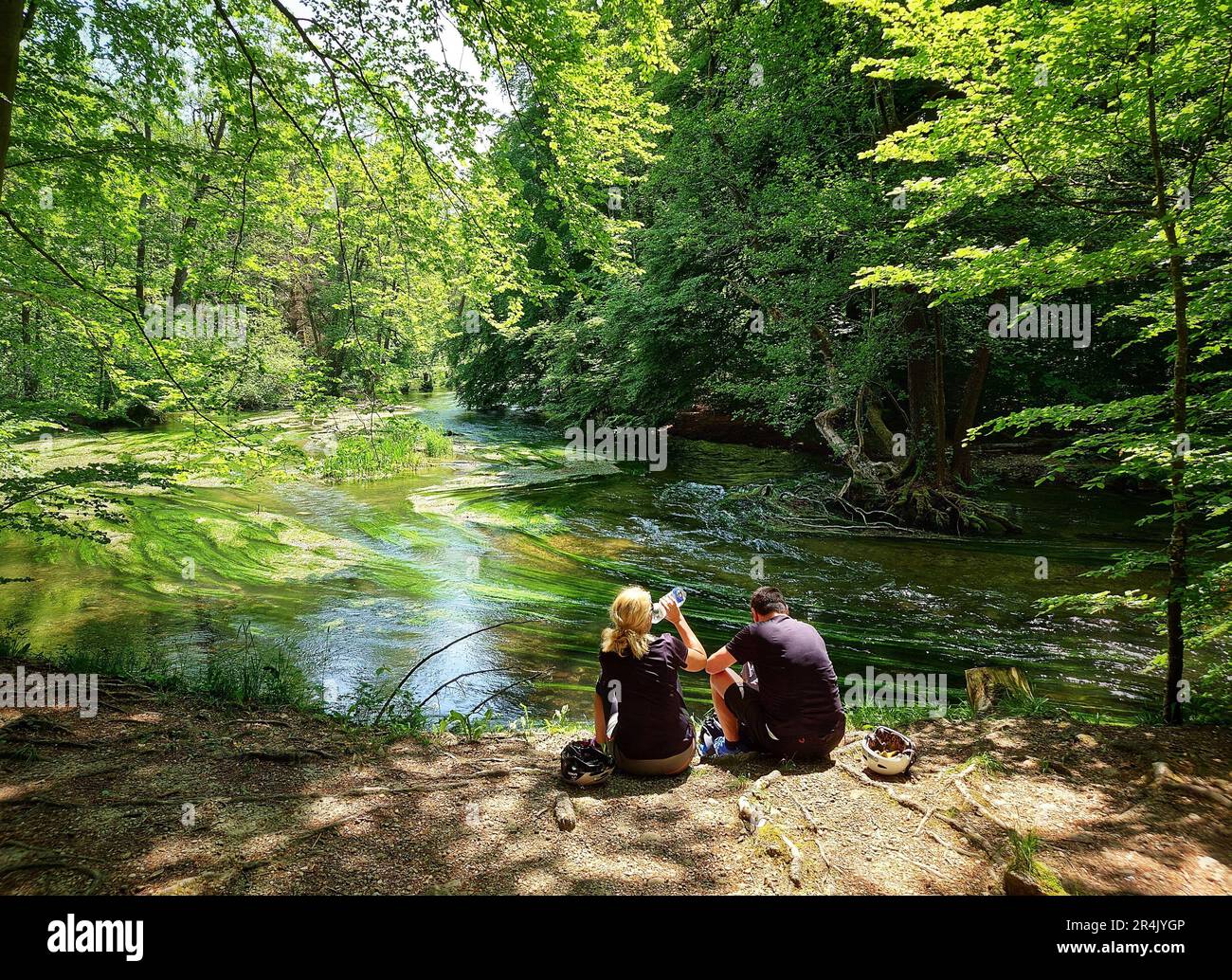 Gauting, Bavaria, Germany. 28th May, 2023. Twi cyclists take a scenic break in front of the WÃÂ¼rm river in a forest in the Gauting area during the Pfingsten holiday weekend. The WÃÂ¼rmtal (Wuerm Valley) is a popular bike oath for bikepackers and long distance cyclists on their way to the Lake Starnberg and destination further south. (Credit Image: © Sachelle Babbar/ZUMA Press Wire) EDITORIAL USAGE ONLY! Not for Commercial USAGE! Stock Photo