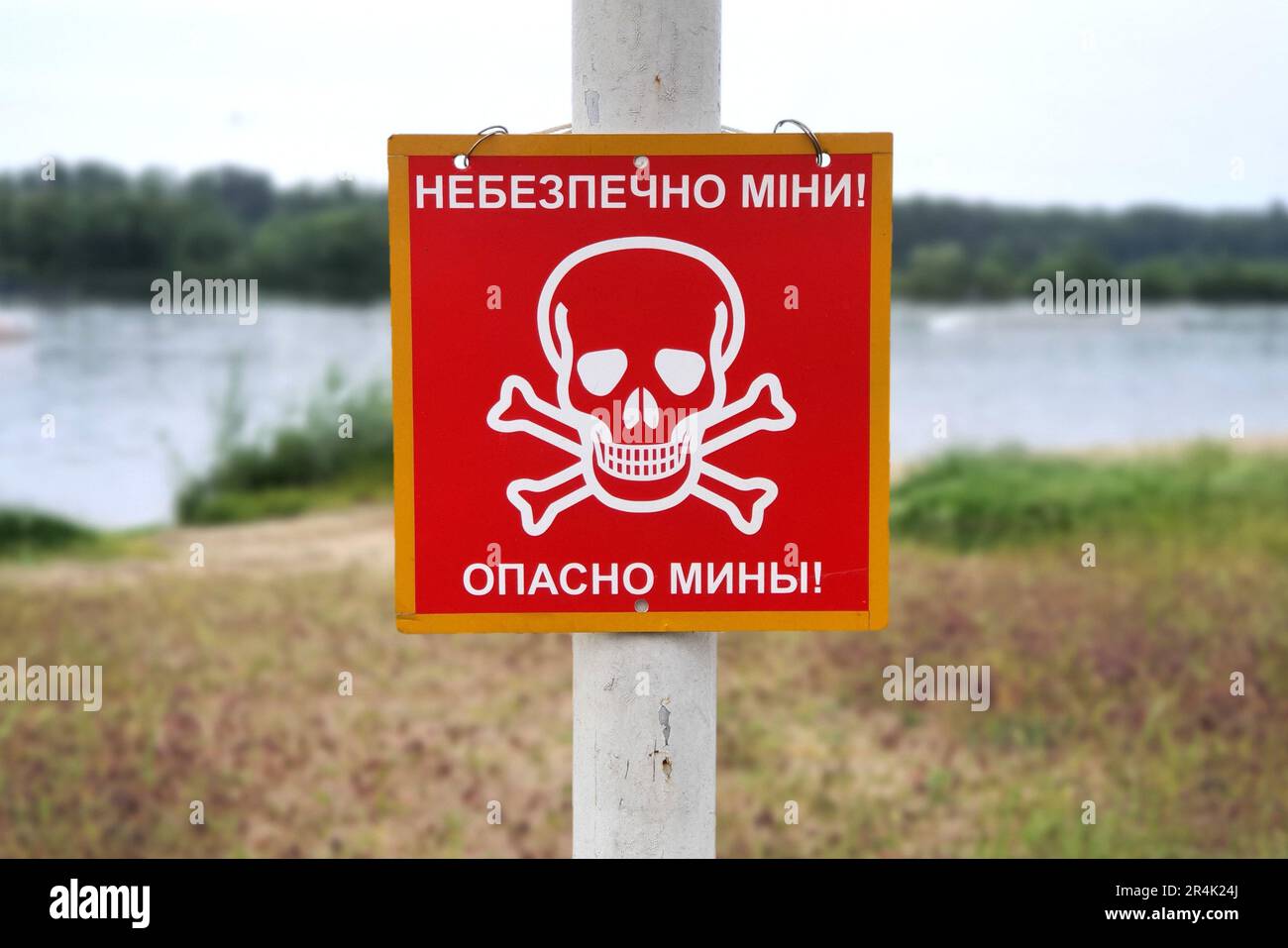 Russia war against Ukraine, Ukrainian war. Red sign skull and bones, danger sign from mines, minefields. inscription in Ukrainian and Russian - Danger Stock Photo