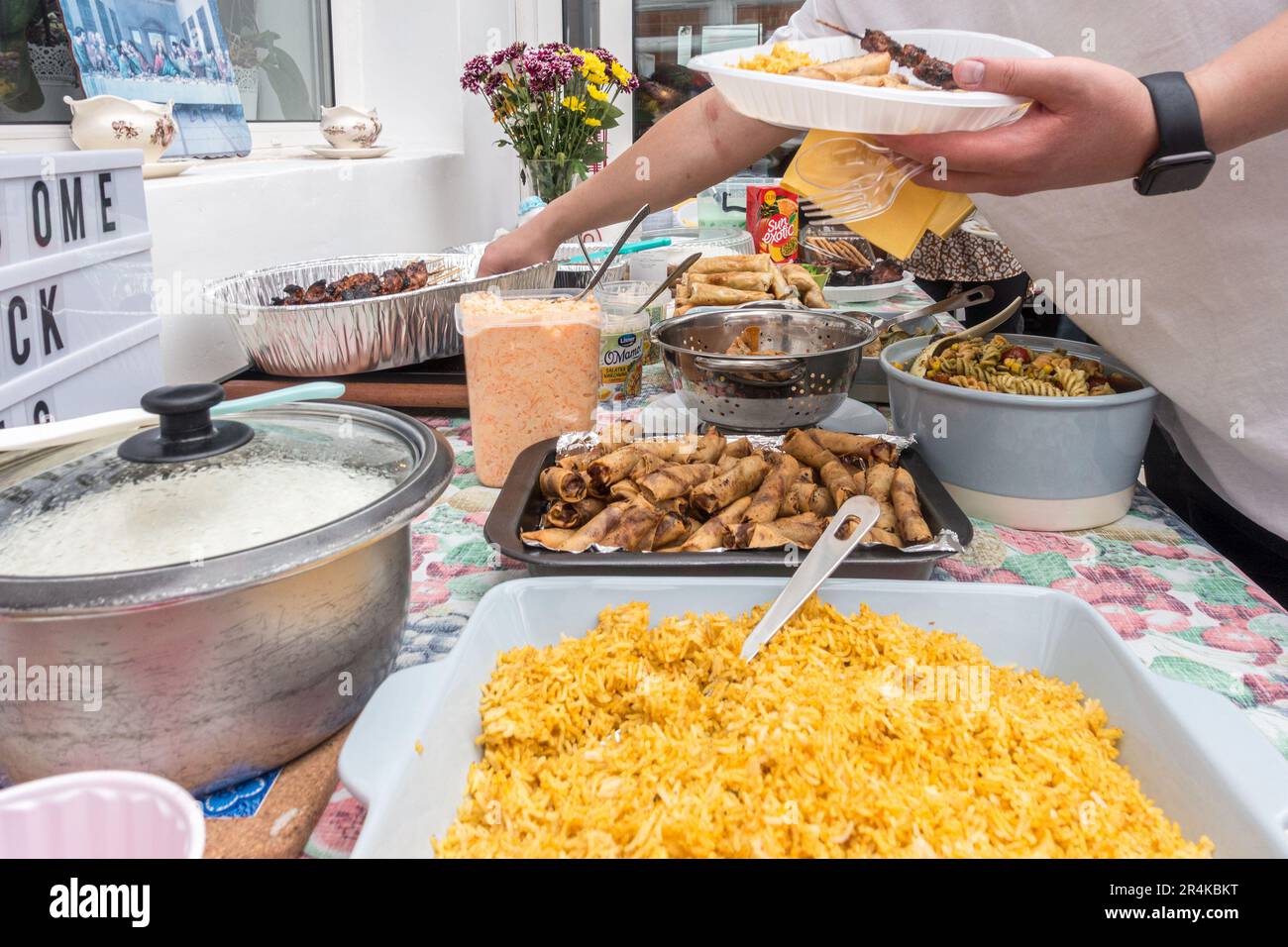 A self service buffet of Filipino dishes at a party with a wide selection of dishes u=including rice, spring roll and pasta salad Stock Photo
