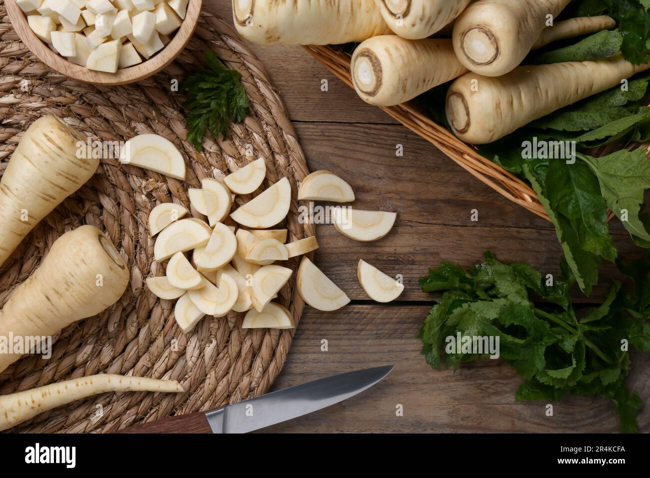 Whole and cut parsnips on wooden table, flat lay Stock Photo