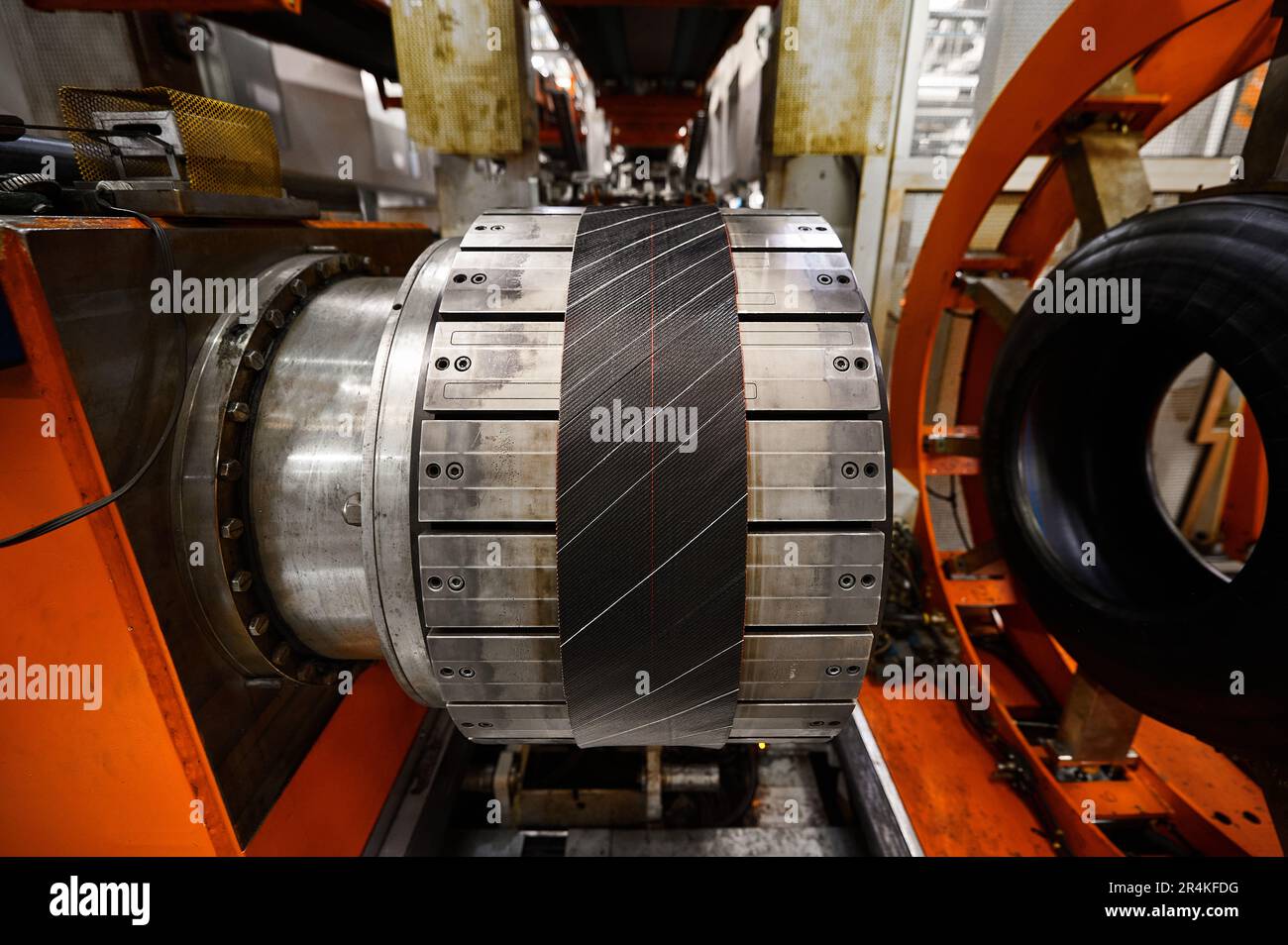 Rolling drum with rubber layers to form car tire at plant Stock Photo