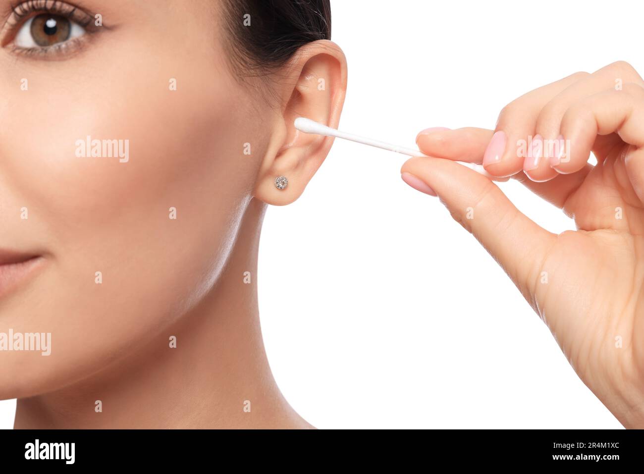 Young woman cleaning ear with cotton swab on white background, closeup