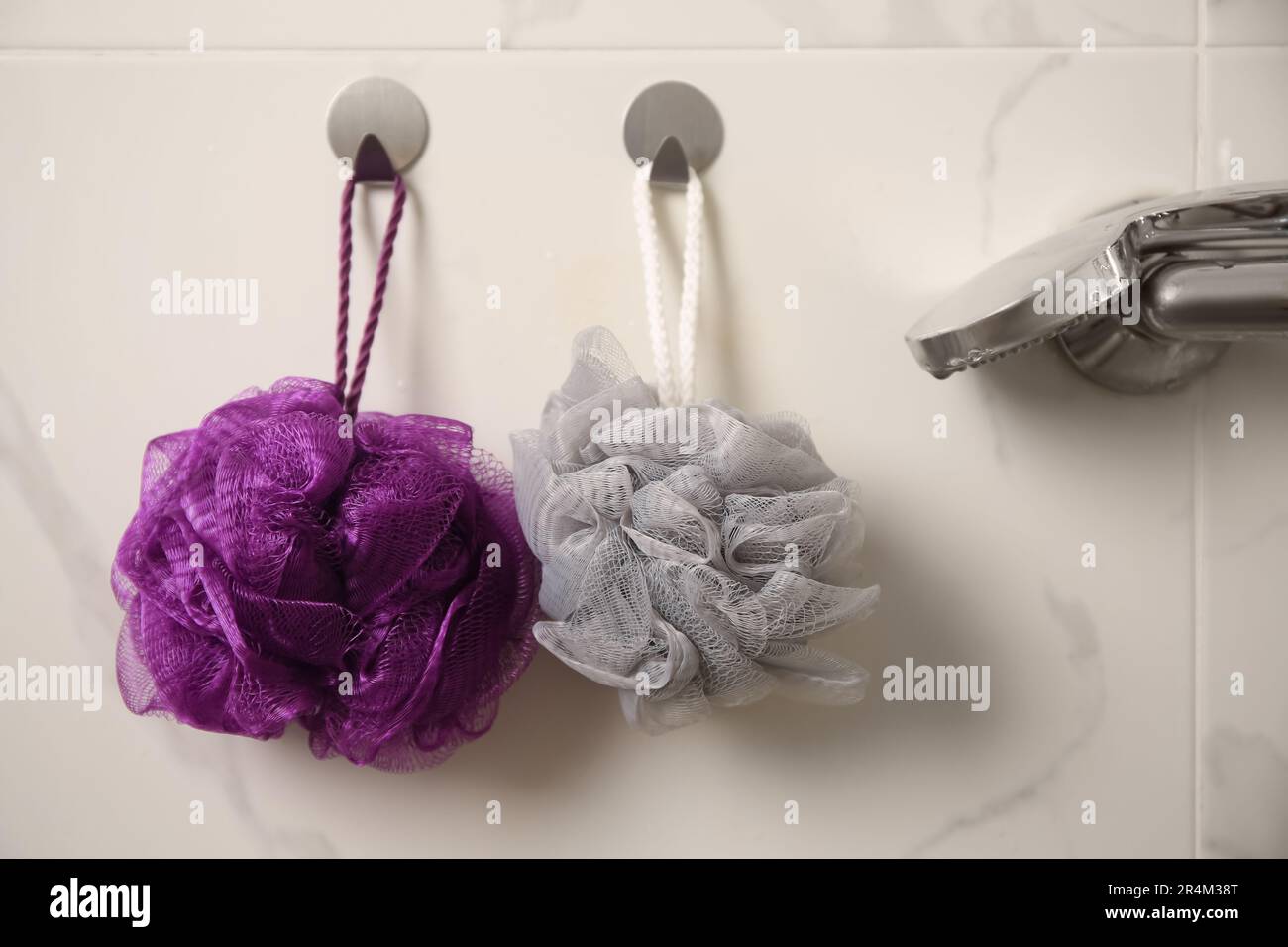 Shower puffs hanging near faucet in bathroom Stock Photo Alamy