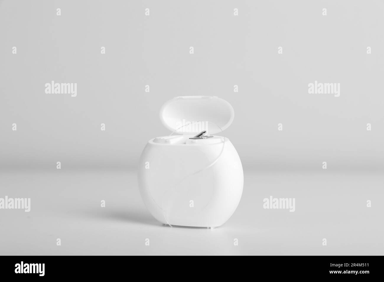Container with dental floss on white background Stock Photo - Alamy