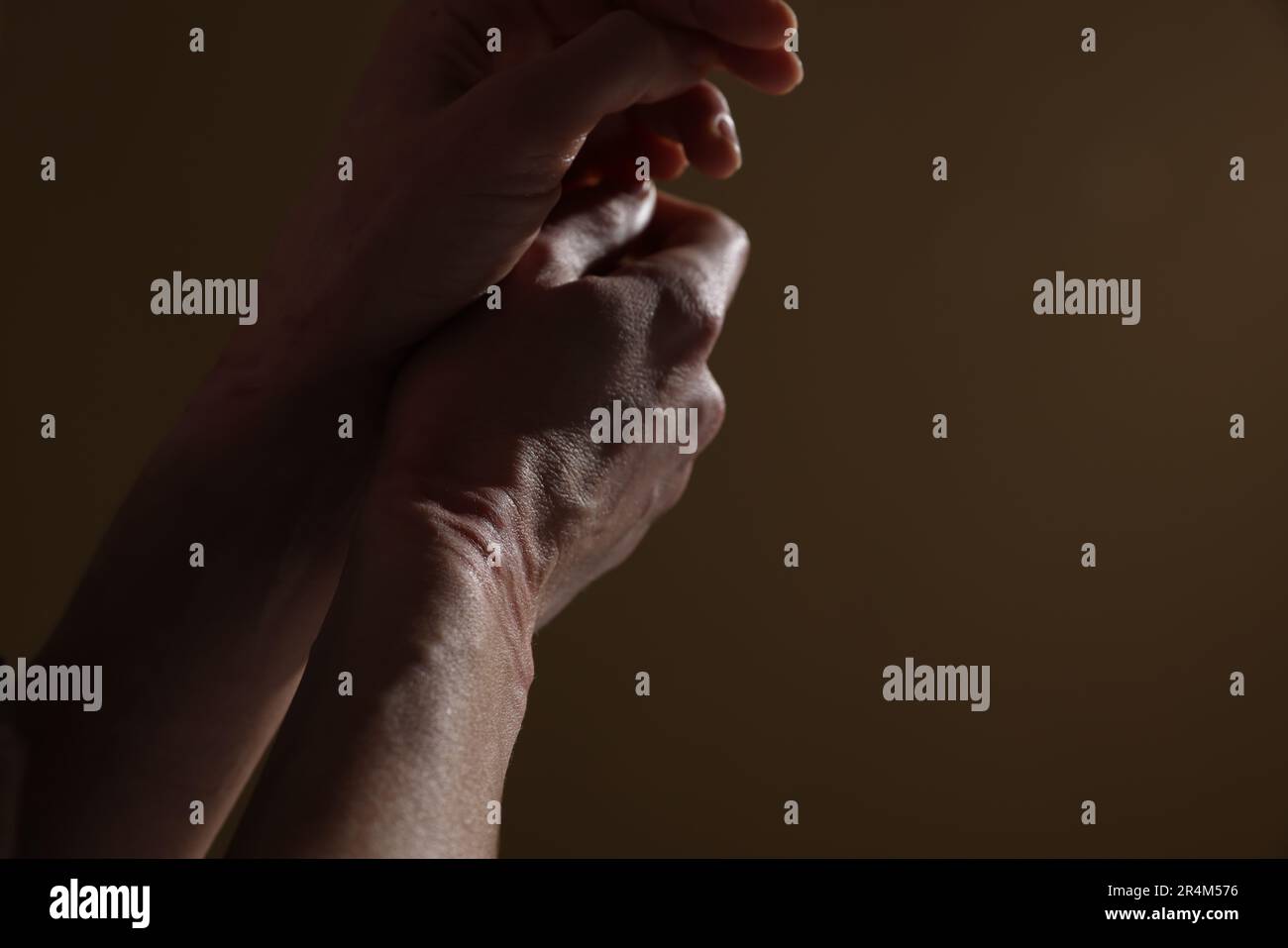 Woman with ligature marks on her wrists against dark background