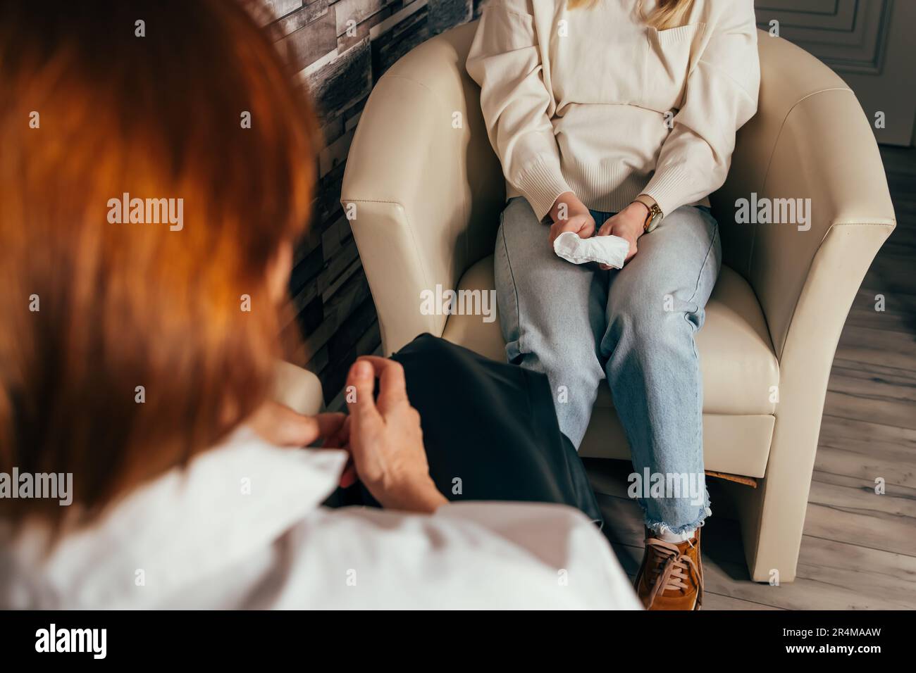 Psychotherapist taking notes during conversation with depressed female Stock Photo