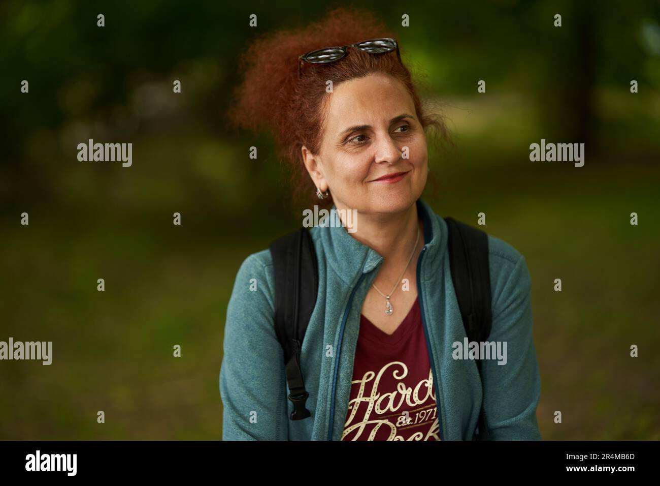 Portrait of a curly hair redhead woman outdoor in the park Stock Photo ...
