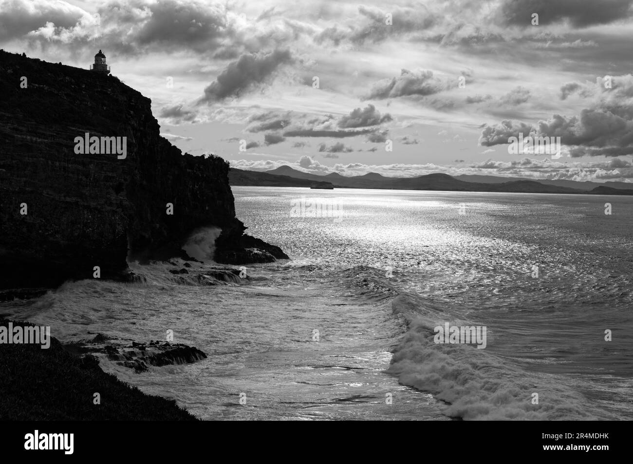 The Taiaroa Head Lighthouse looks out to sea warning of the dangerous cliffs for boats coming into Otago Harbour. Stock Photo