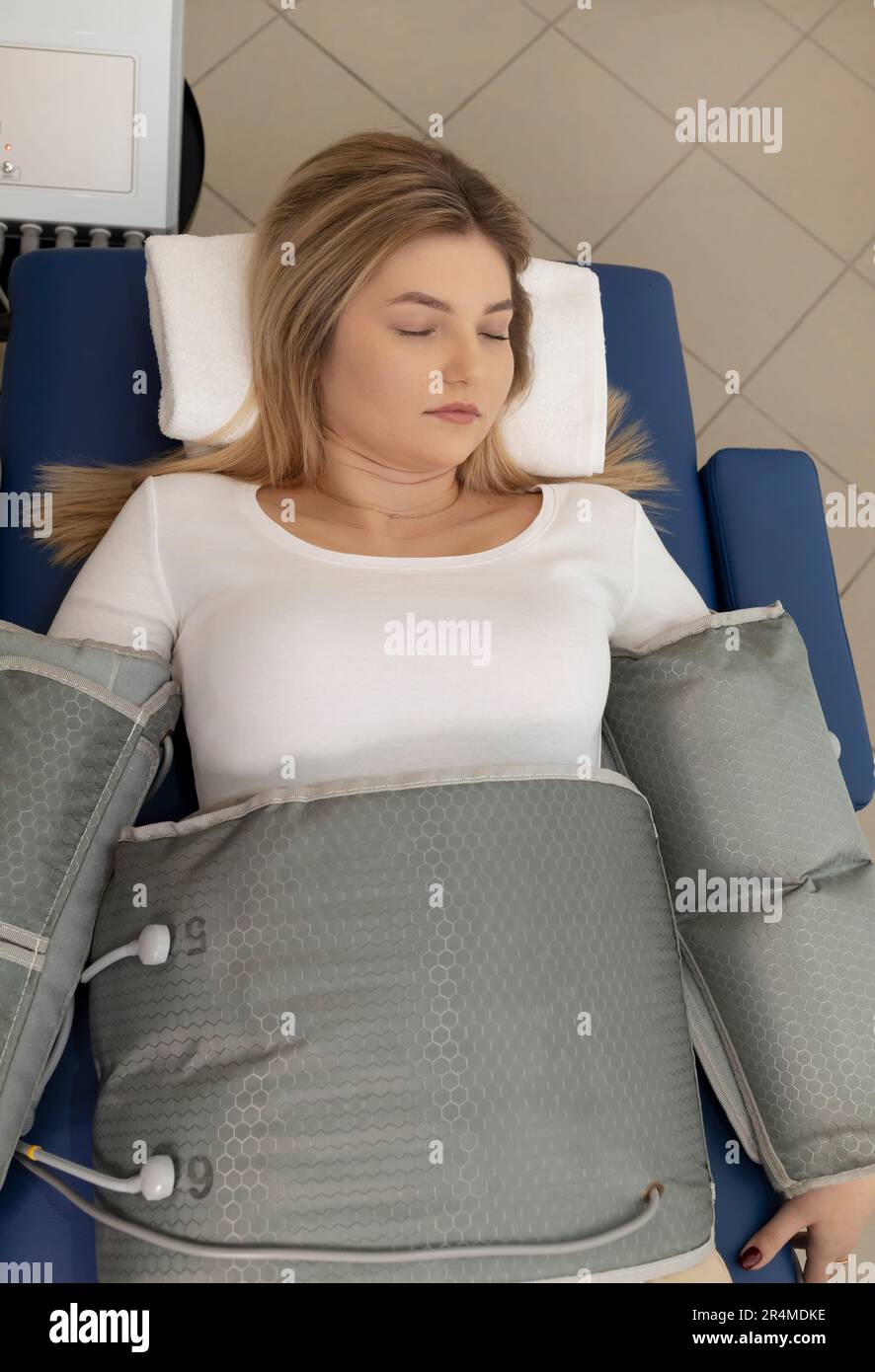 Top view pressure therapy procedure. Woman lying in massaging suit in