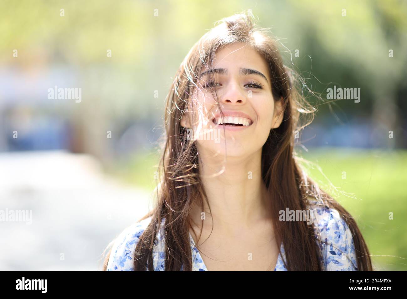 Front view portrait of a happy woman laughing with tousled hair a windy day Stock Photo