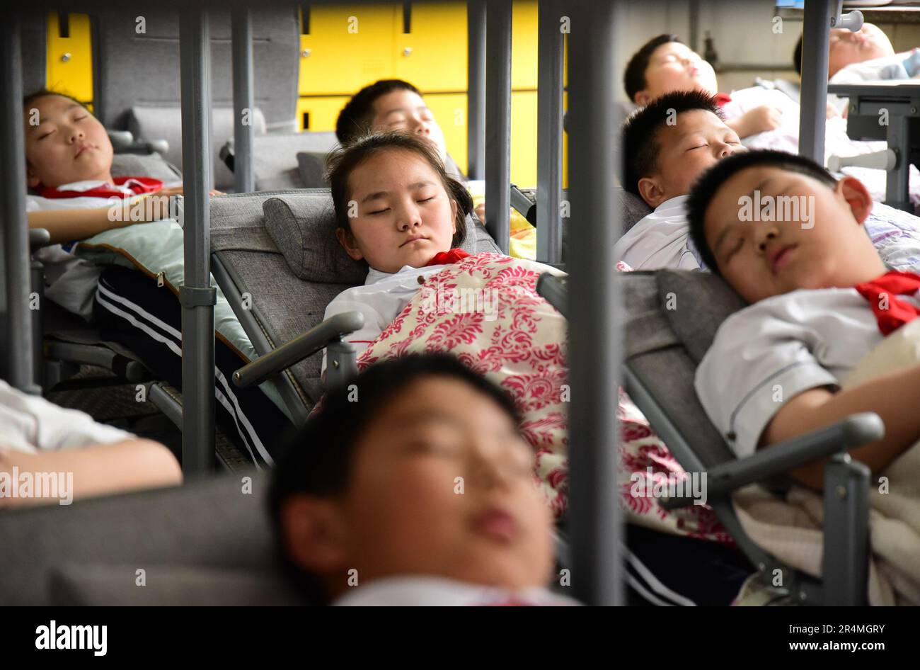 HANDAN, CHINA - MAY 29, 2023 - Primary school students use 'reclining desks and chairs' for lunch break in Handan, Hebei province, China, May 29, 2023 Stock Photo
