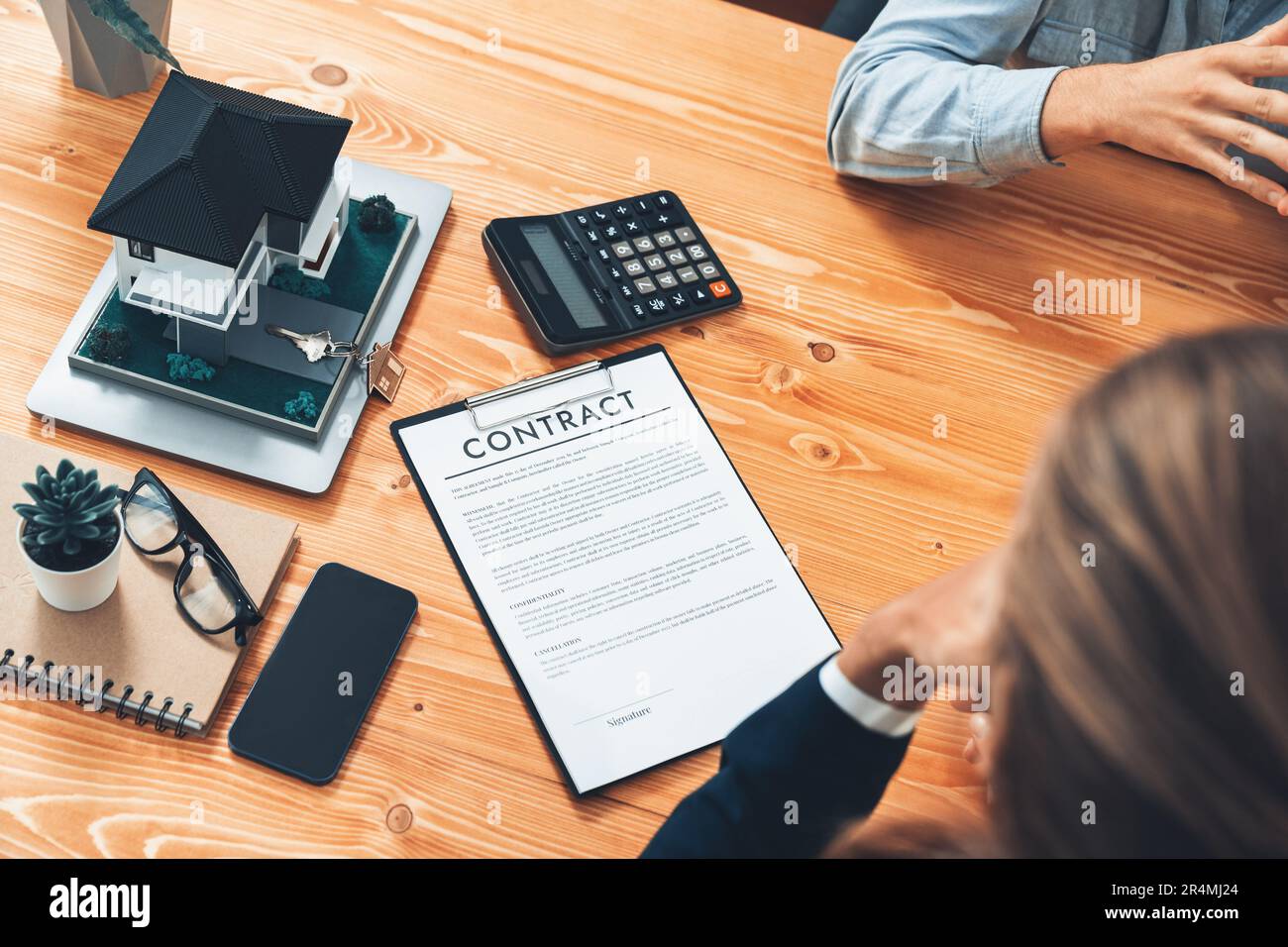 Client and real estate agent review loan contract, discussing term