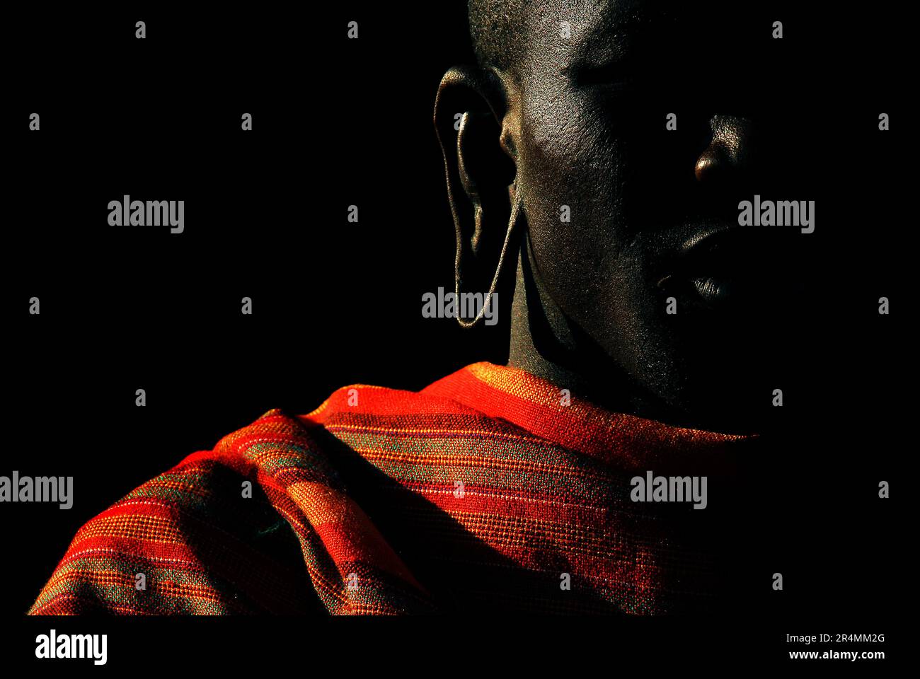 A member of the Masai tribe displays his stretched earlobes in Masai-Mara National Reserve, Kenya. Stock Photo