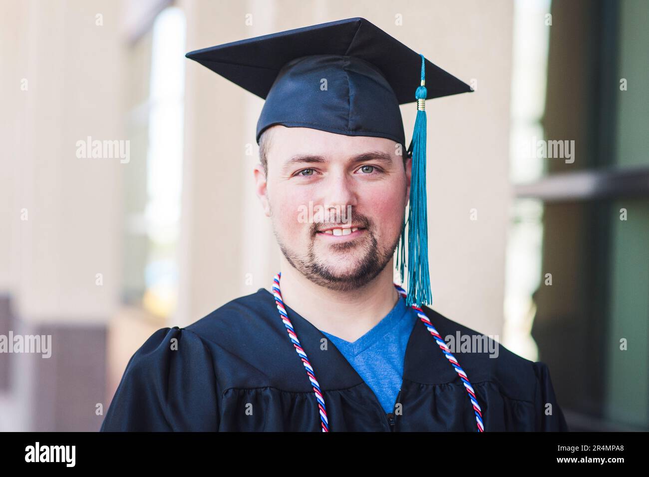 Smiling portrait of male graduate in black cap and gown Stock Photo
