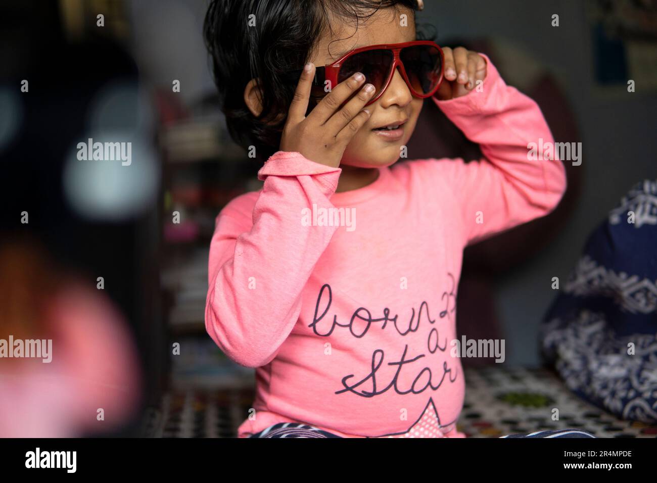 Adorable Cute Girl Wearing Sunglasses And Making Fun At Indoors Stock Adorable cute girl wearing sunglasses and making fun at indoors stock