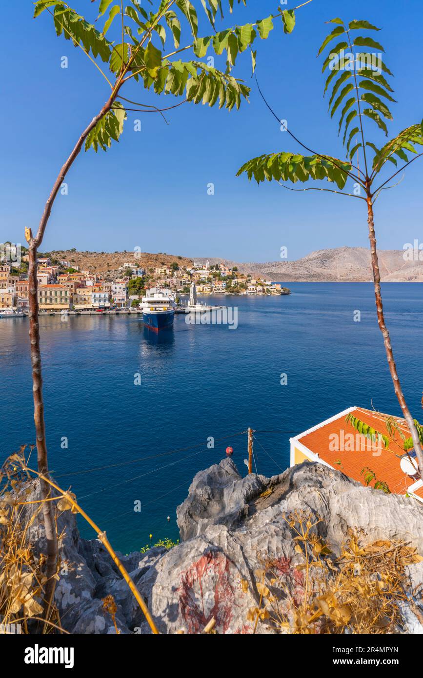 View of ferry boat in harbour from elevated position in Symi Town, Symi Island, Dodecanese, Greek Islands, Greece, Europe Stock Photo