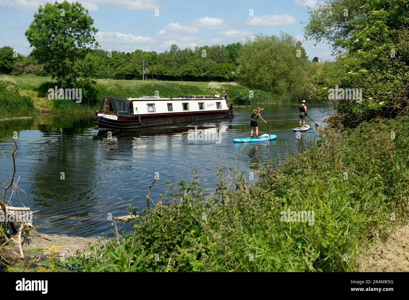 Paddleboarders and a narrowboat on the River Avon, Stratford-upon-Avon, Warwickshire, UK Stock Photo