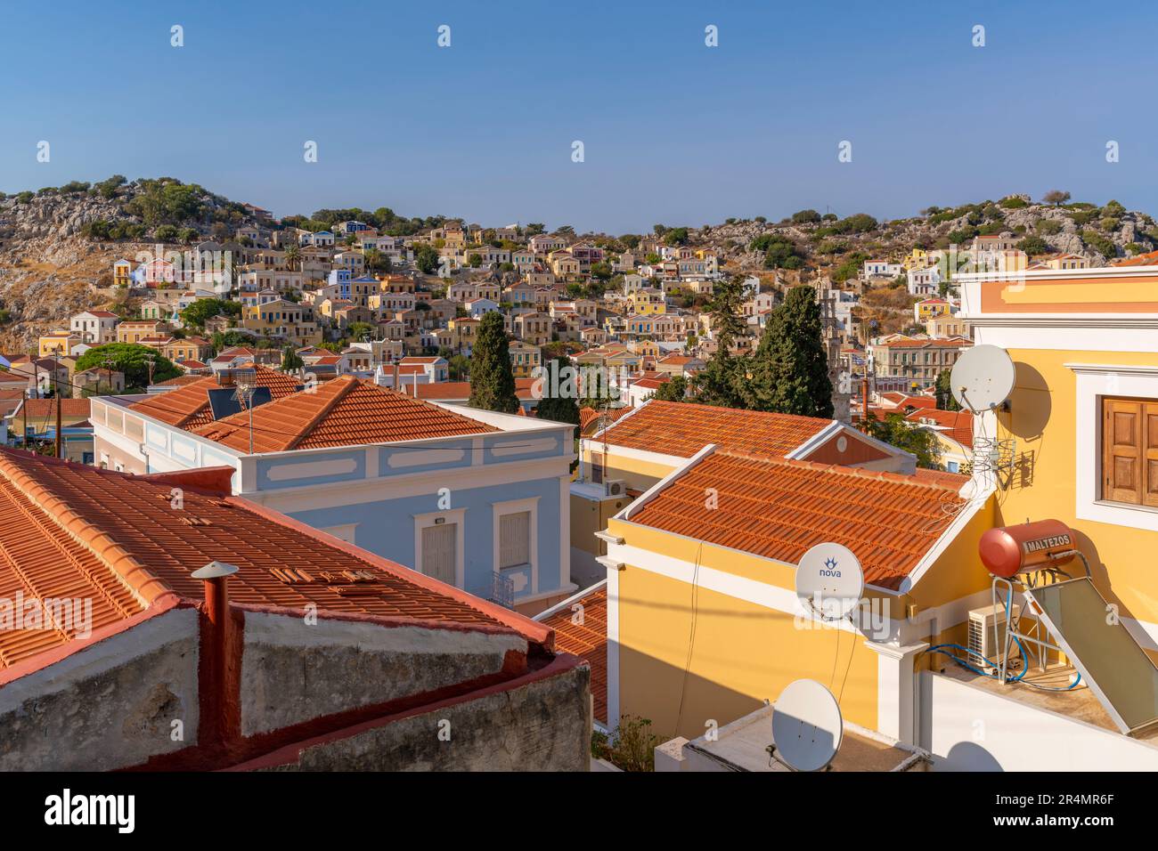 View of colourful buildings from elevated position in Symi Town, Symi Island, Dodecanese, Greek Islands, Greece, Europe Stock Photo
