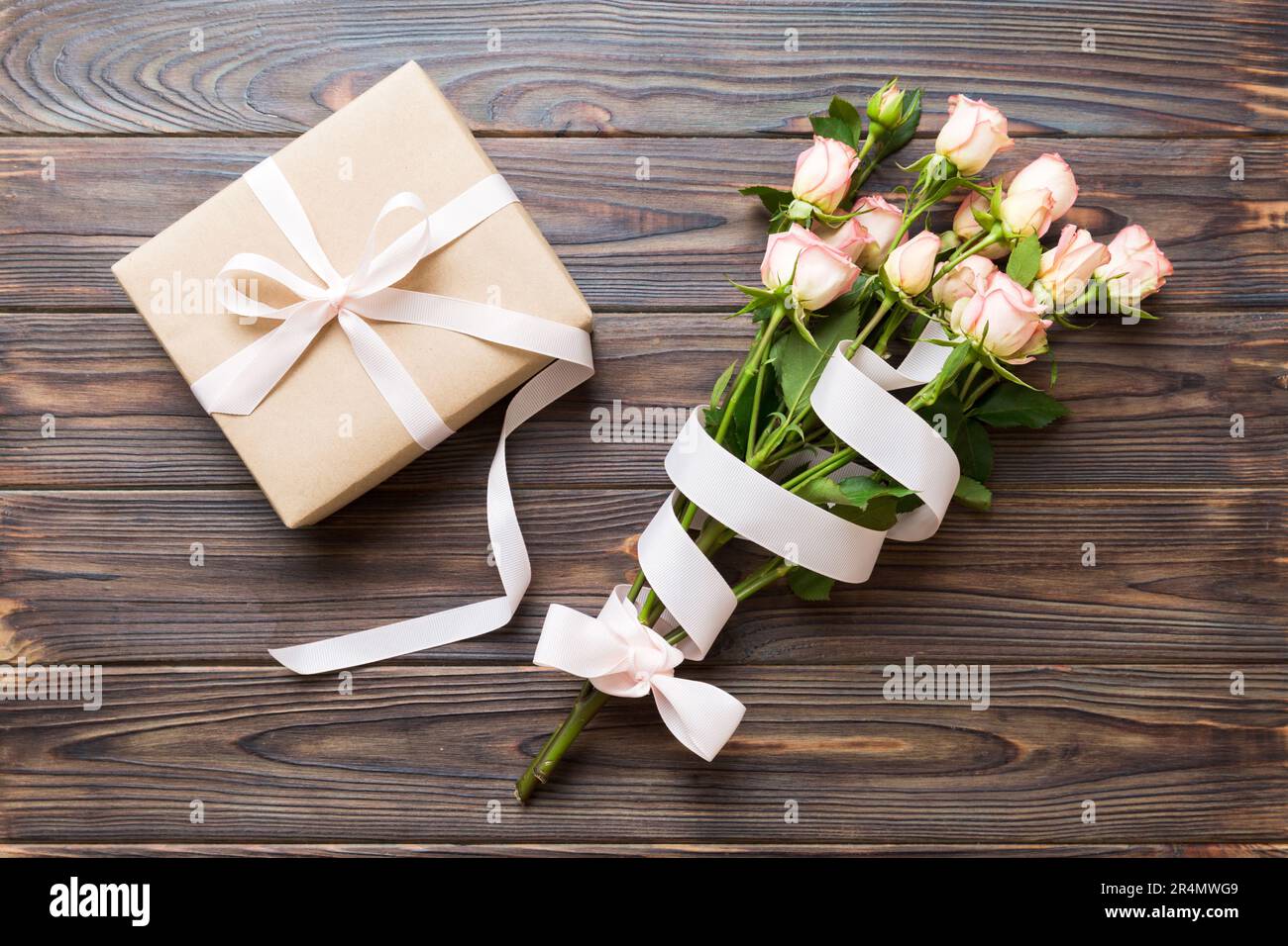 design concept with pink rose flower and gift box on colored table ...