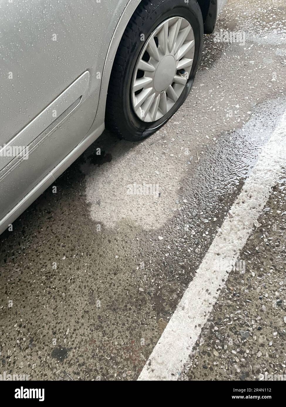 Car tires flat on wet parking lot Stock Photo Alamy