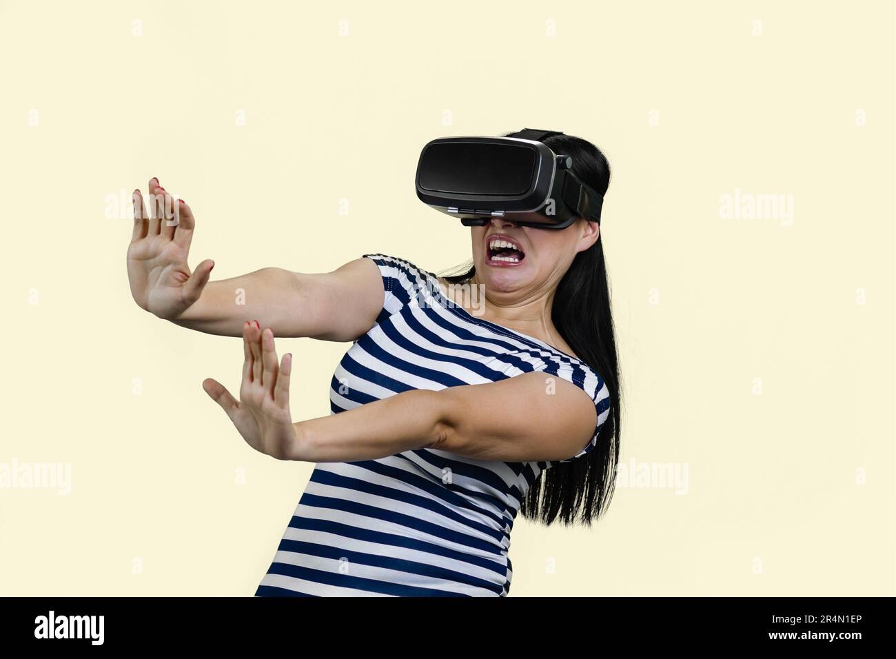 Young woman in vr headset is stratched her hands in fear. Experiencing