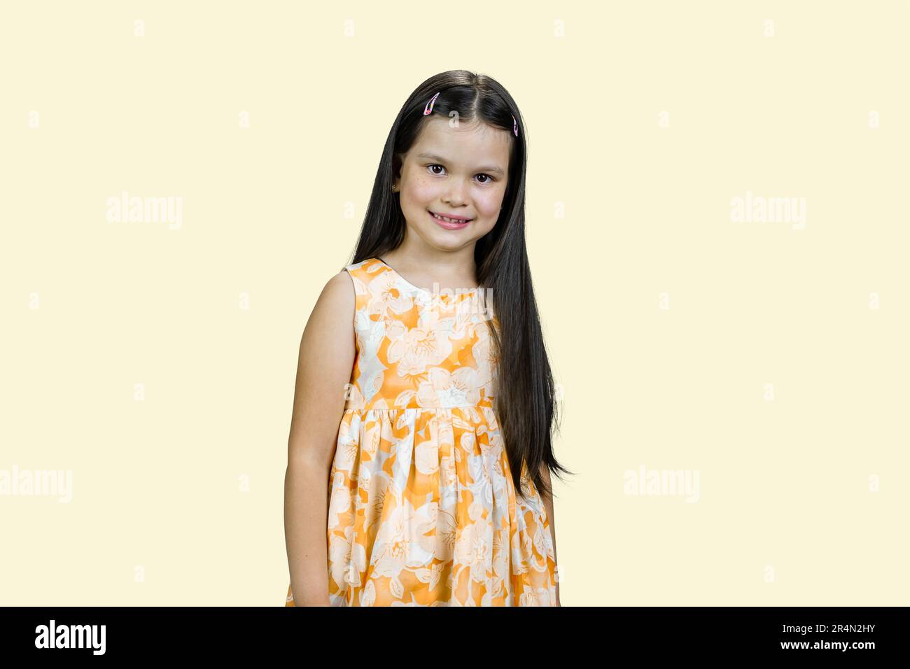 Cute smiling little girl in yellow dress. Isolated on pastel yellow ...
