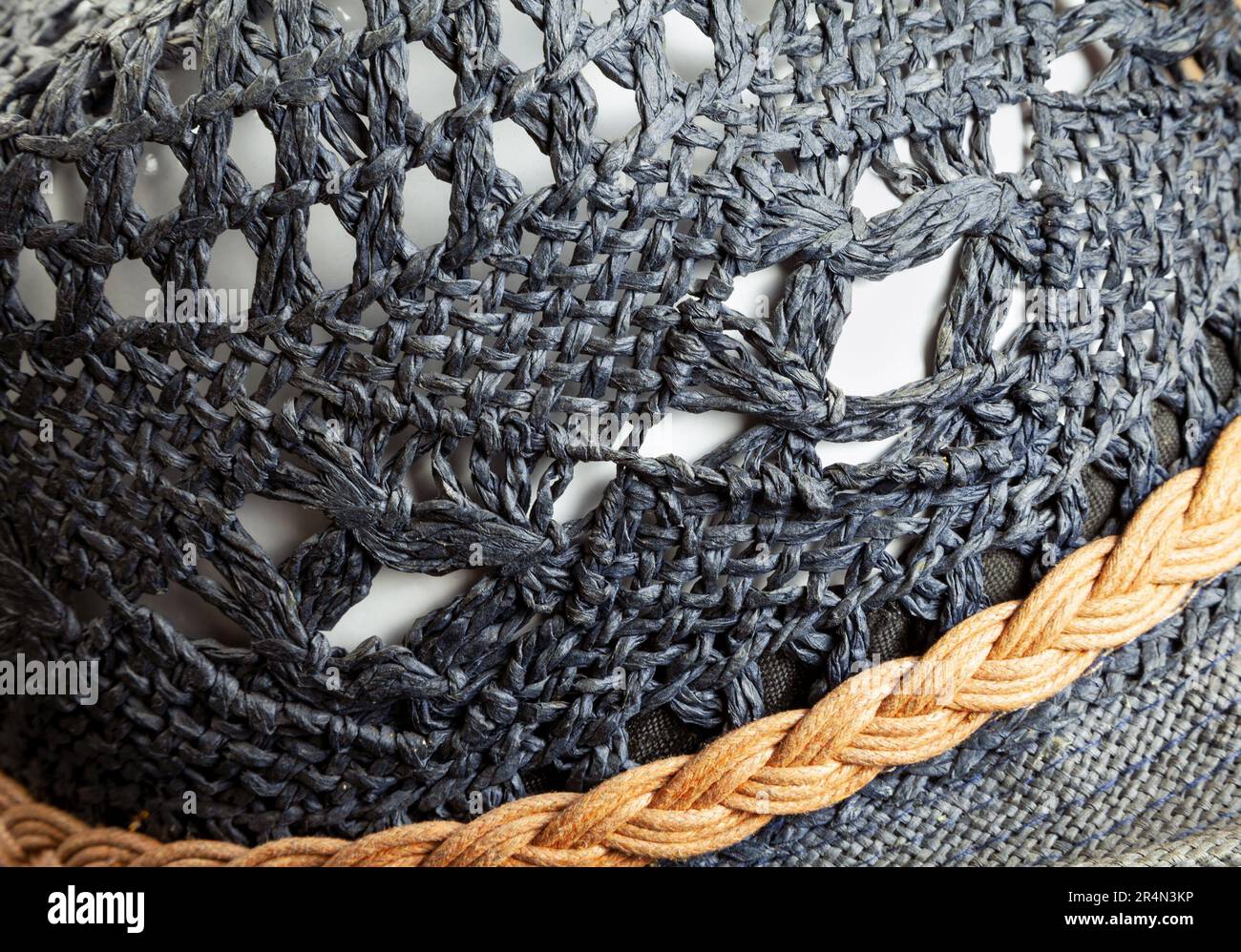 Summer paper straw hat closeup, woven toyo straw ornamental background. Fibers of natural paper