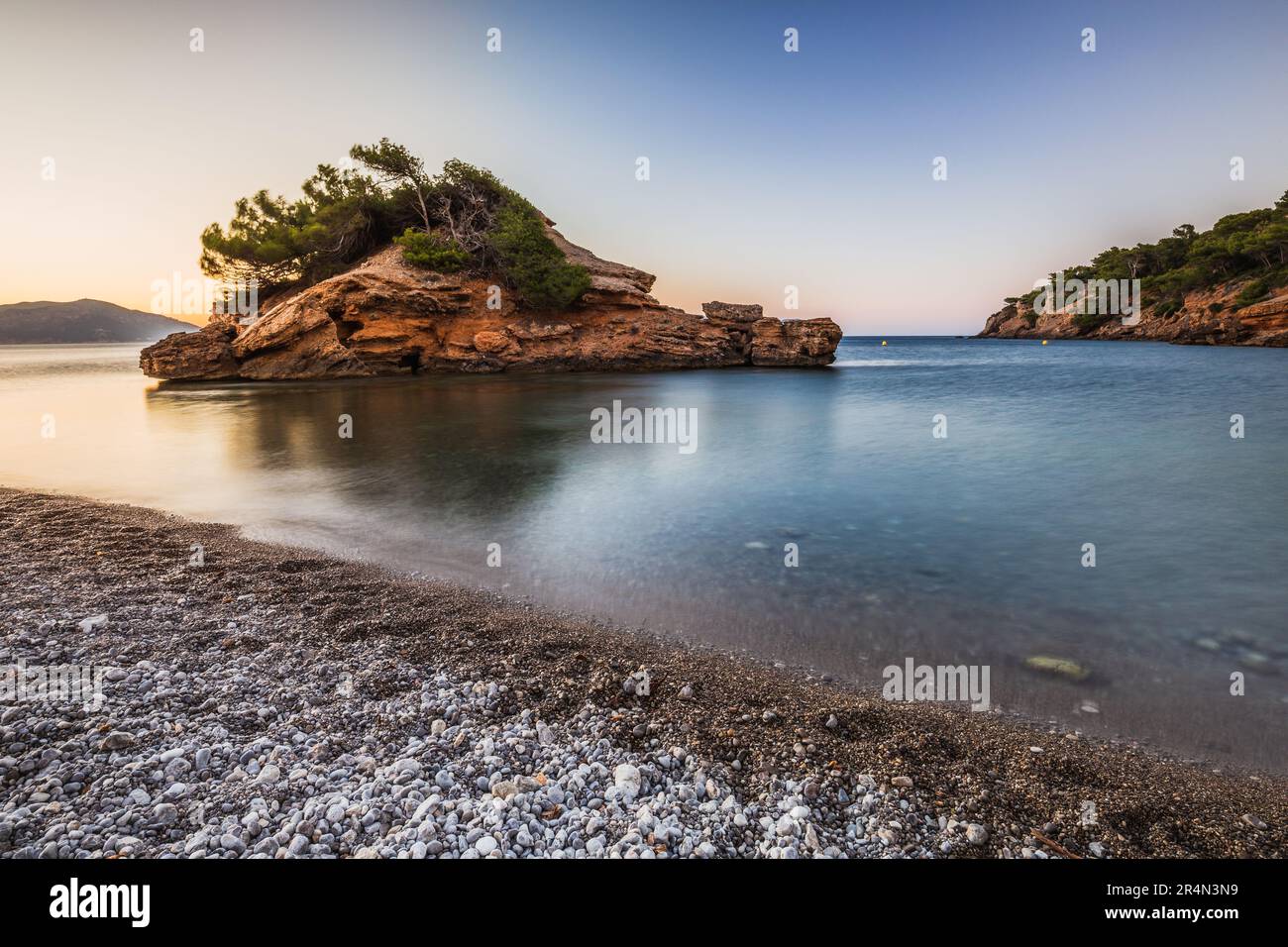 Smooth water and the small island. Stock Photo