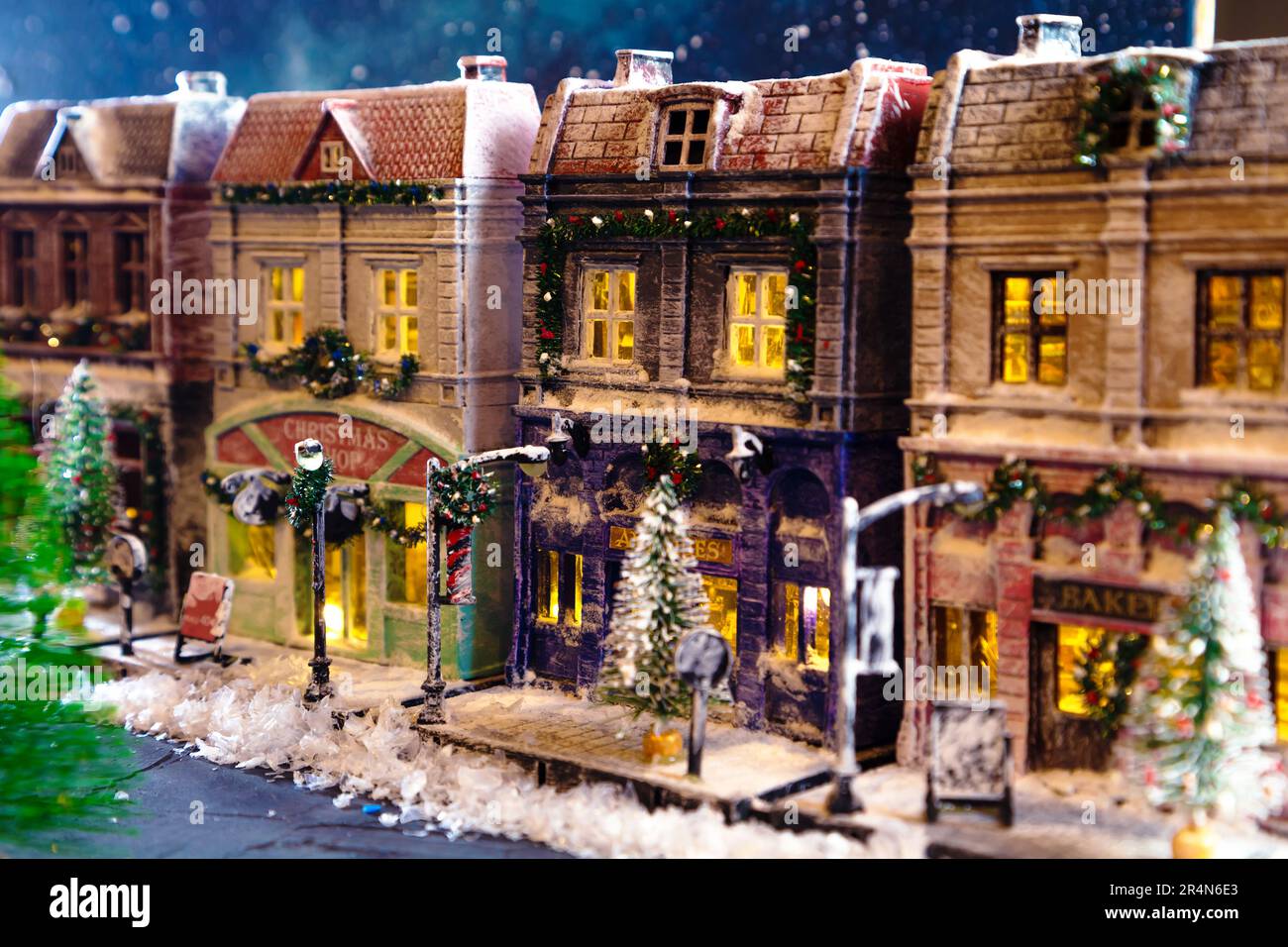 Night snow-covered European street decorated for Christmas. Homemade decorated toy houses. All elements of the image are made and drawn by hand.  Sele Stock Photo