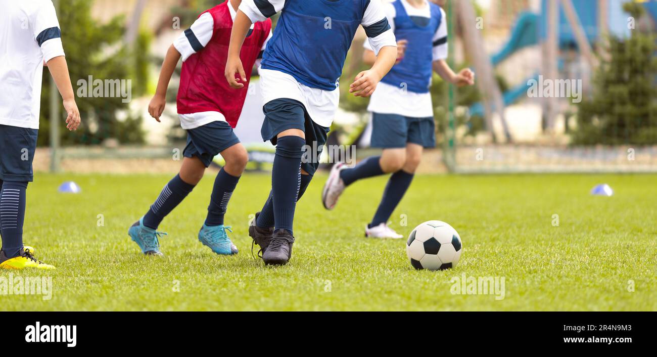Young Boys Running During Football Training. . Players in Training Unifrms Compete in Training Match. Happy Kids on Soccer Sports Practice Stock Photo
