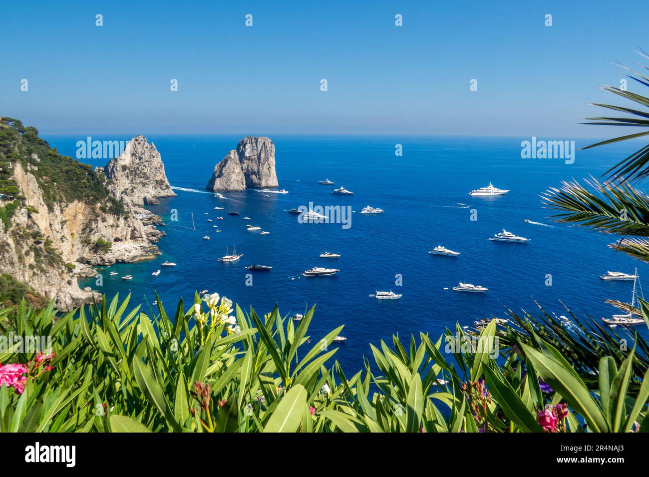 Los Faraglioni di Capri, los acantilados de Capri, son una serie de tres pequeños islotes. Barcos navegando a su alrededor, isla de Capri, Italia Stock Photo