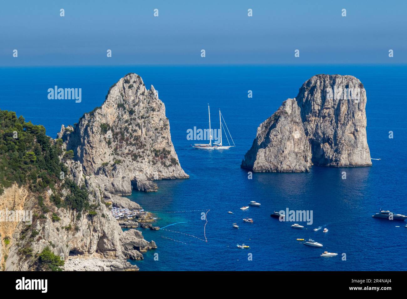 Los Faraglioni di Capri, los acantilados de Capri, son una serie de tres pequeños islotes. Barcos navegando a su alrededor, isla de Capri, Italia Stock Photo