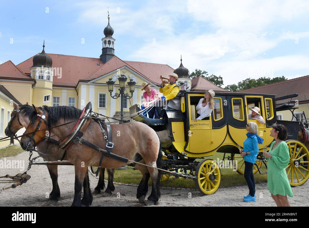 29 May 2023, Saxony, Hohenprießnitz, Bad Düben: On a stagecoach in the castle courtyard of the baroque castle Hohenprießnitz, coach driver Dietmar Dietze blows the post horn for the onward journey after a break. Every year at Whitsun, friends and acquaintances with stagecoaches, Landauers, wagonettes and hunting carriages meet with Siegfried Händler from the carriage driving service Bad Düben for a day trip to the surrounding area in northern Saxony. Photo: Waltraud Grubitzsch/dpa Stock Photo