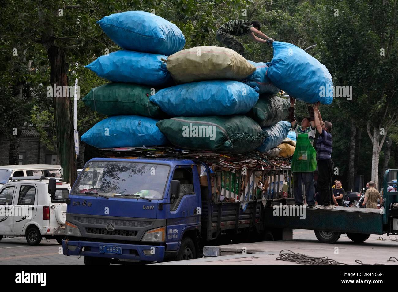 Workers load plastic bottles collected for recycling onto a truck in ...