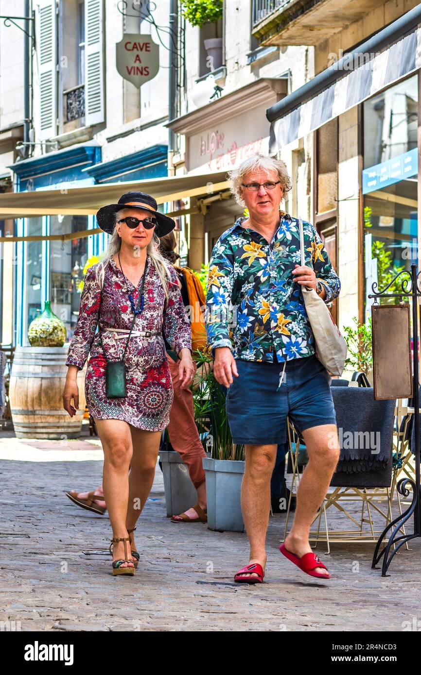 Middle-aged casually dressed tourists walking through town street - Loches, Indre-et-Loire (37), France. Stock Photo