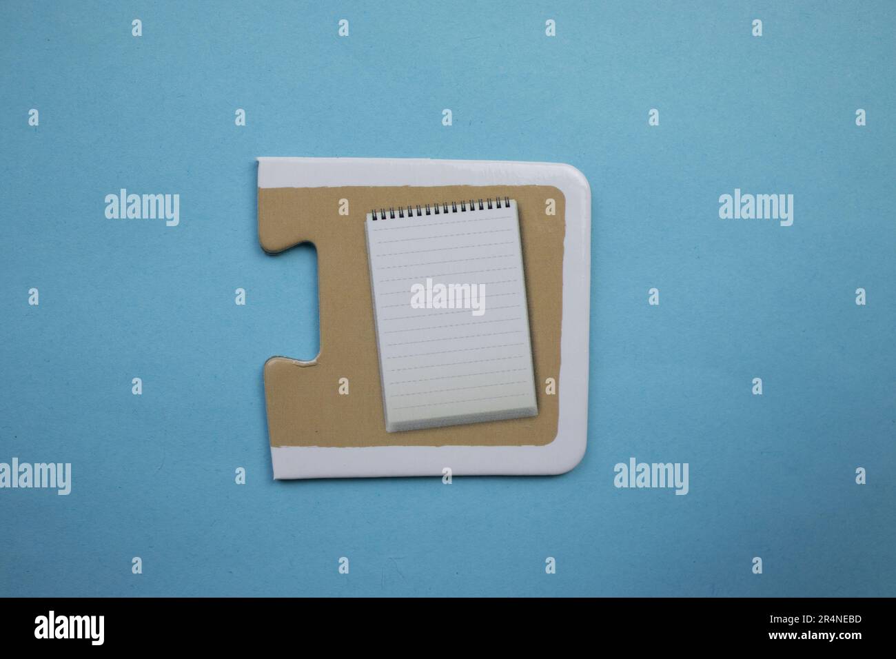 Picture puzzles placed on a blue background. Notepad Stock Photo