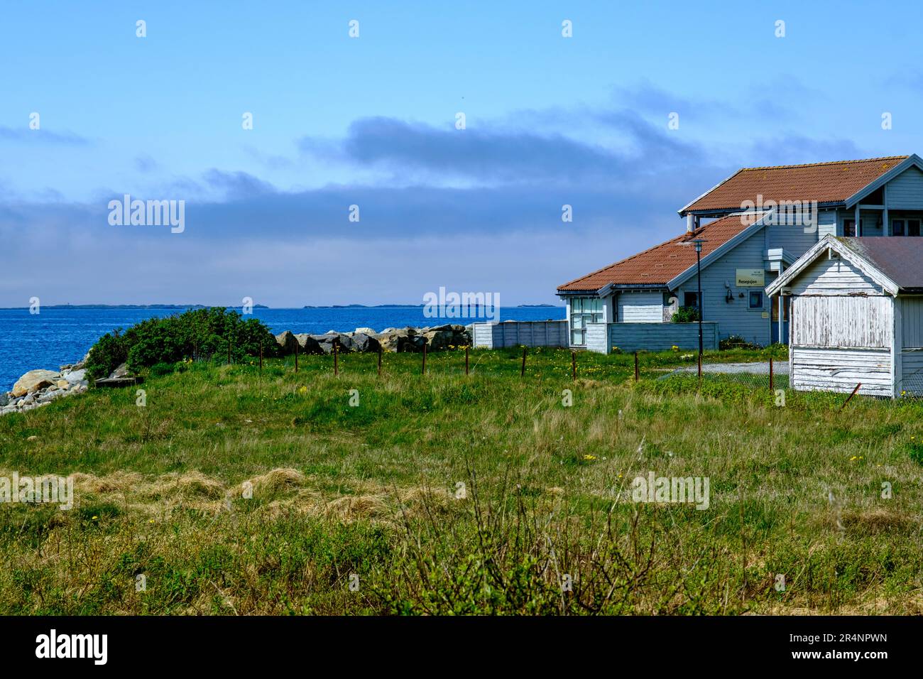 Olberg; Olbergstranden; Raege; Norway; May 20 2023, Traditional Wooden Build Norwegain House Looking Out To Sea Surrounded By Green Grass Fillds With Stock Photo